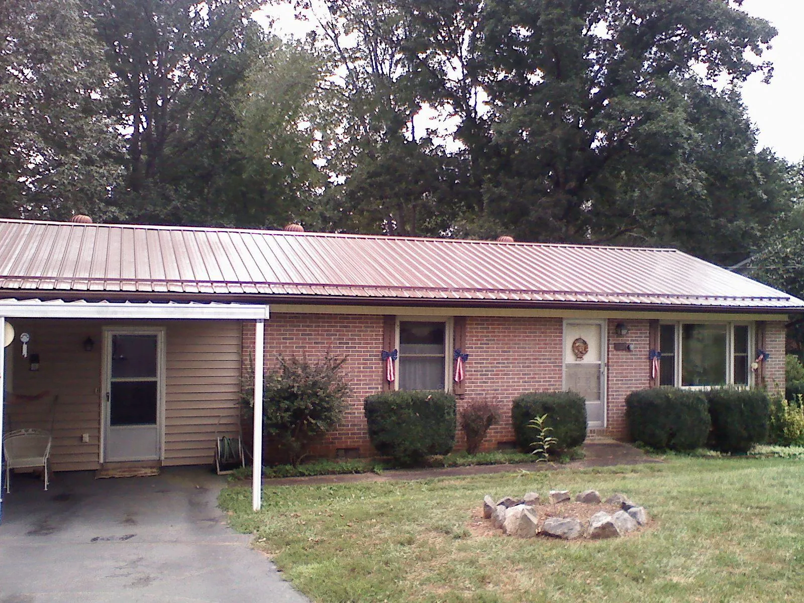 Bronze metal roof and carport on a brick ranch home — Roof Repair work by our crew in Circleville